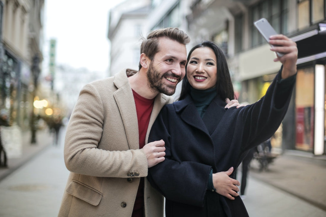 man and a woman taking a selfie together in the middle of a high street